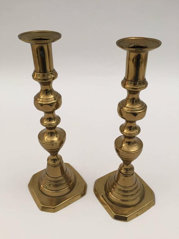 Lot - PAIR OF CONTINENTAL BRASS PRICKET STICKS Turned vasiform stems on  triangular bases with paw feet. Heights 19.5.